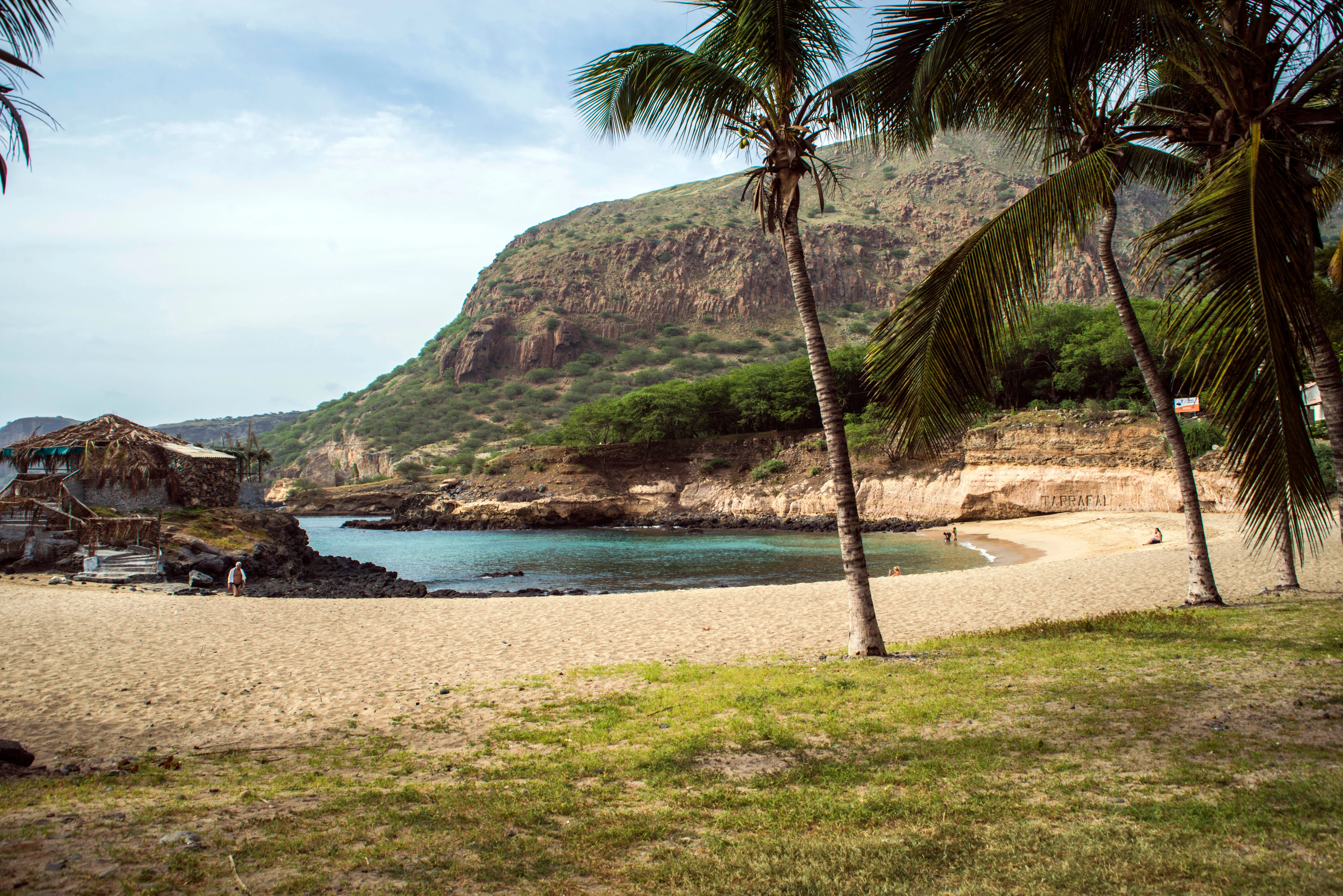 A warm Cape Verde-style coastal beach scene with blue water and summer light