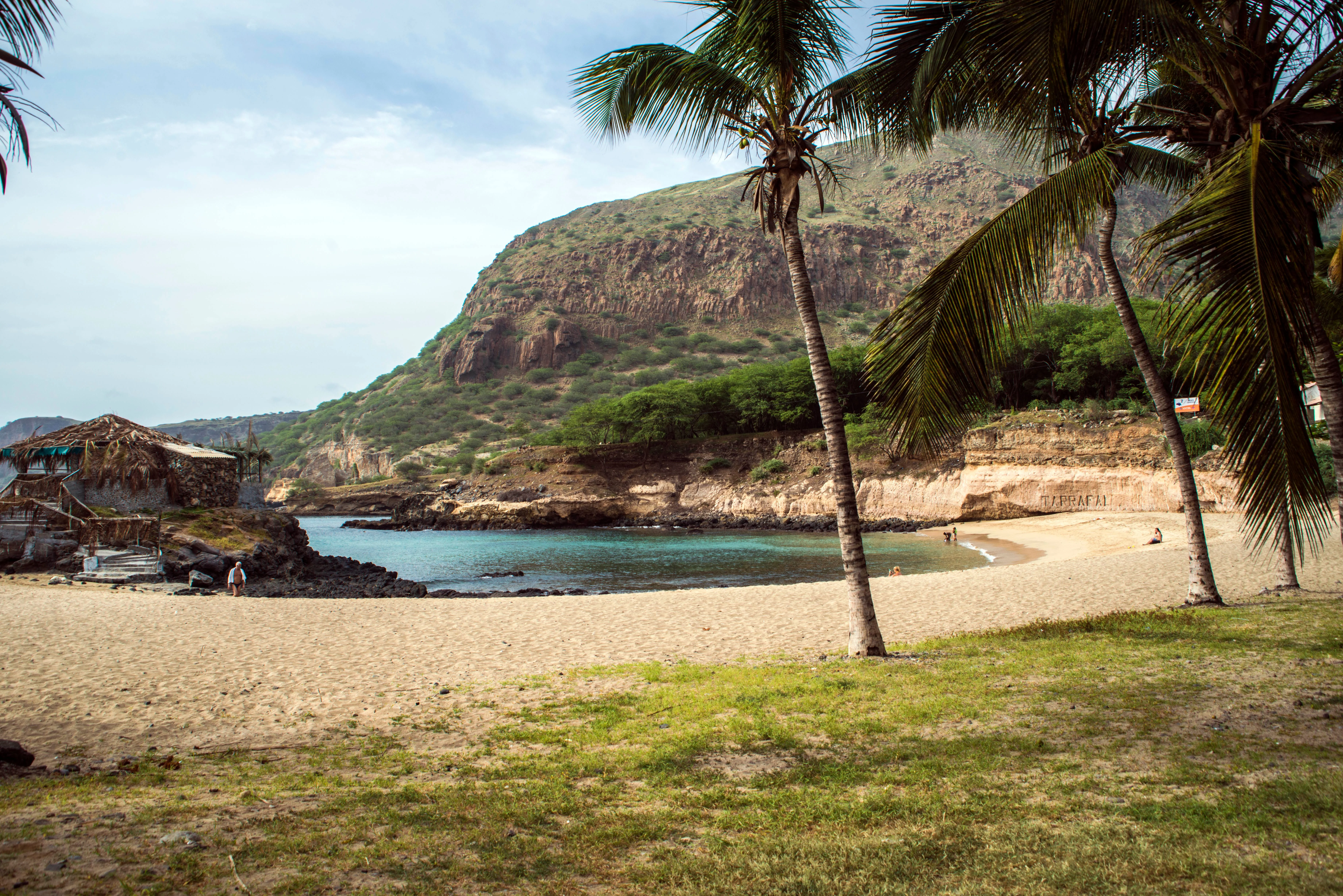 A warm Cape Verde-style coastal beach scene with blue water and summer light