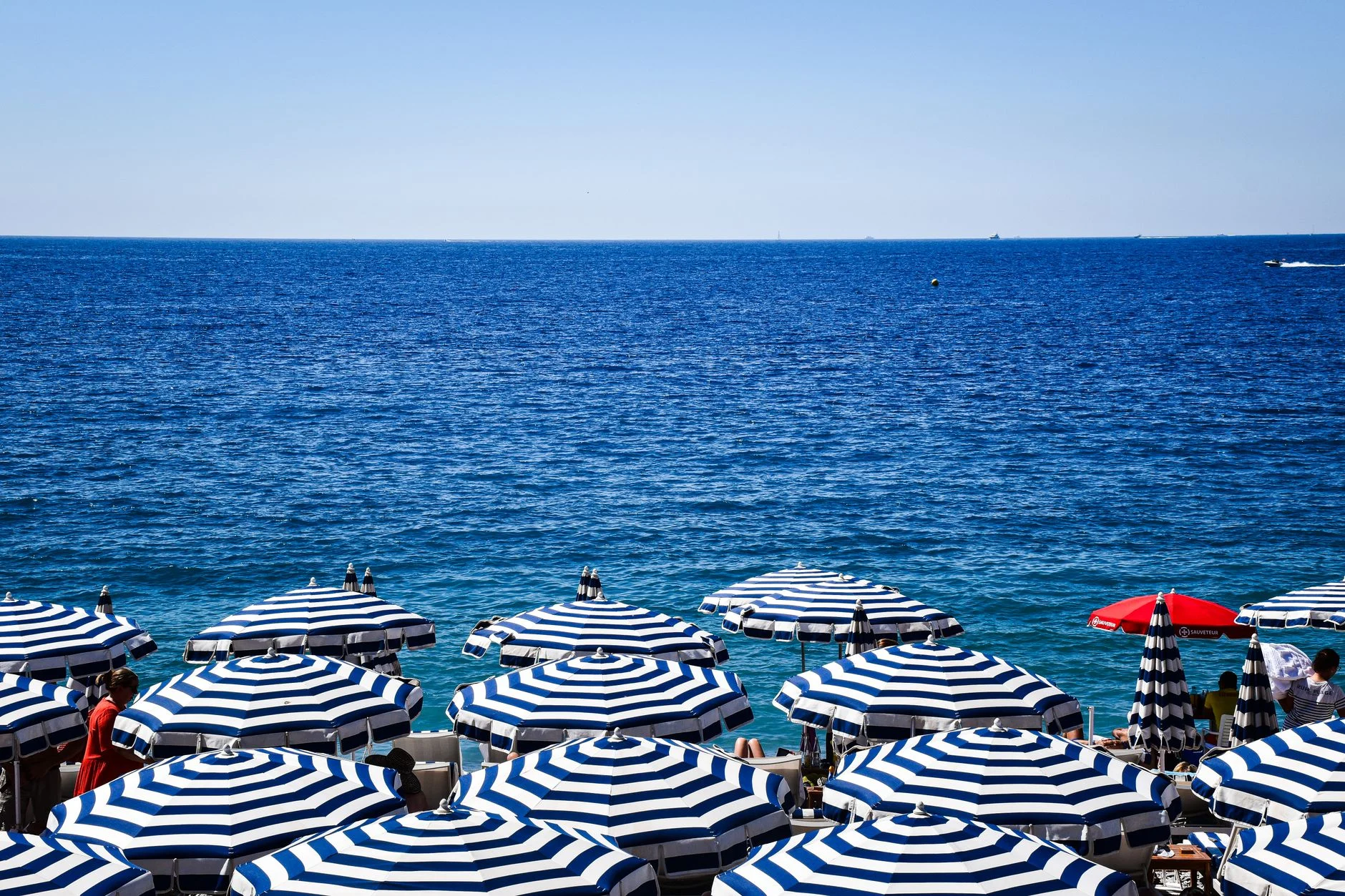 Beach umbrellas beside the azure sea on the French Riviera
