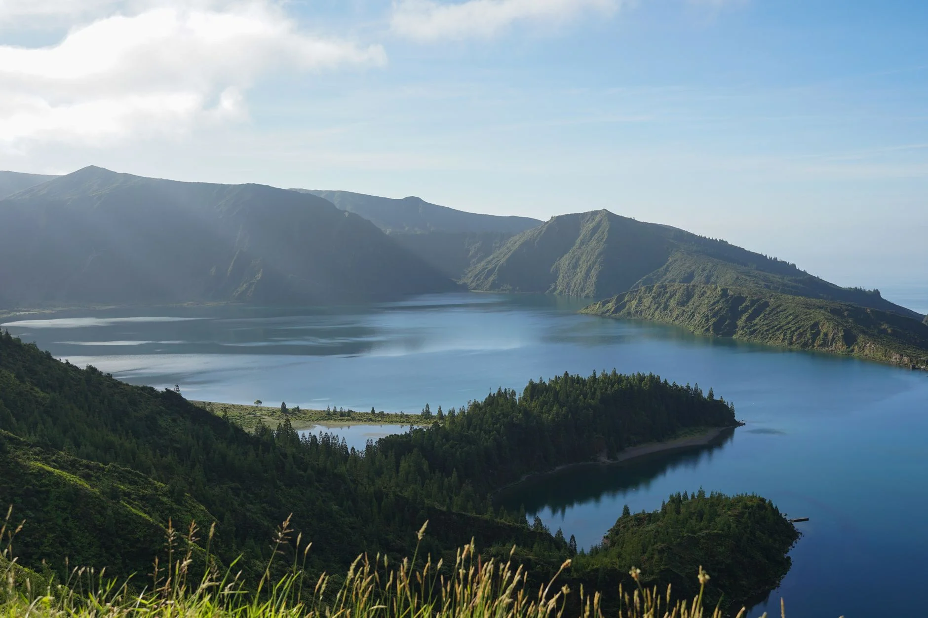 A green crater lake on São Miguel, Azores, under a blue sky