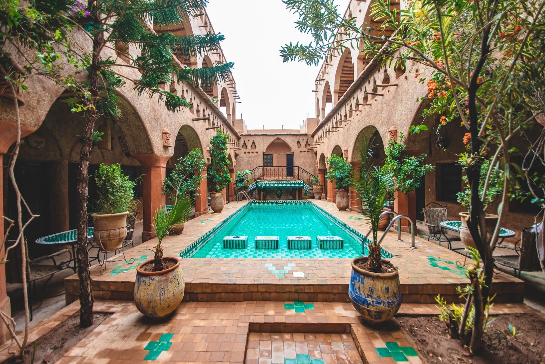 A tiled riad courtyard with plants in Morocco
